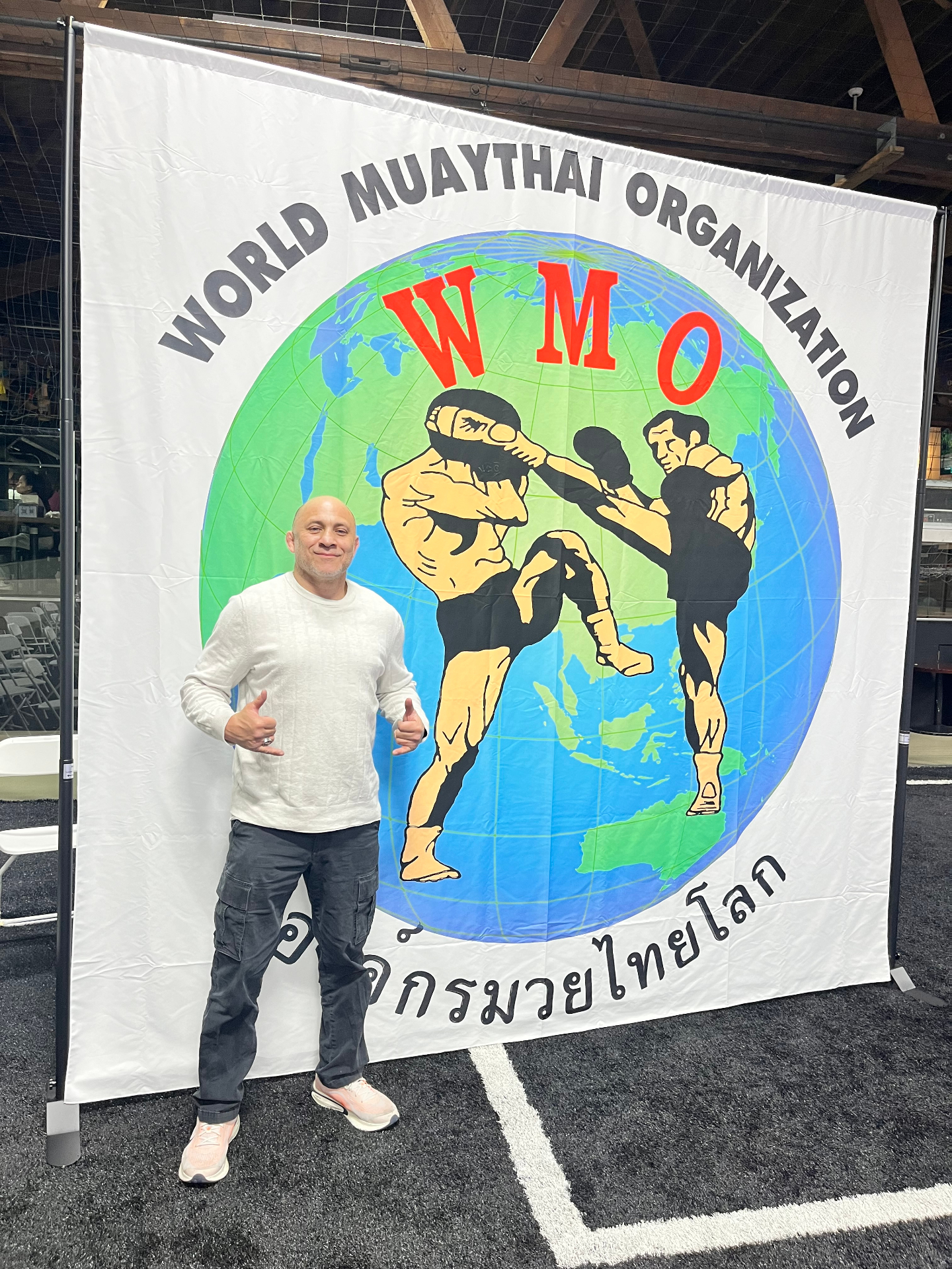 Andre Madiz in front of the World Muaythai Organization banner