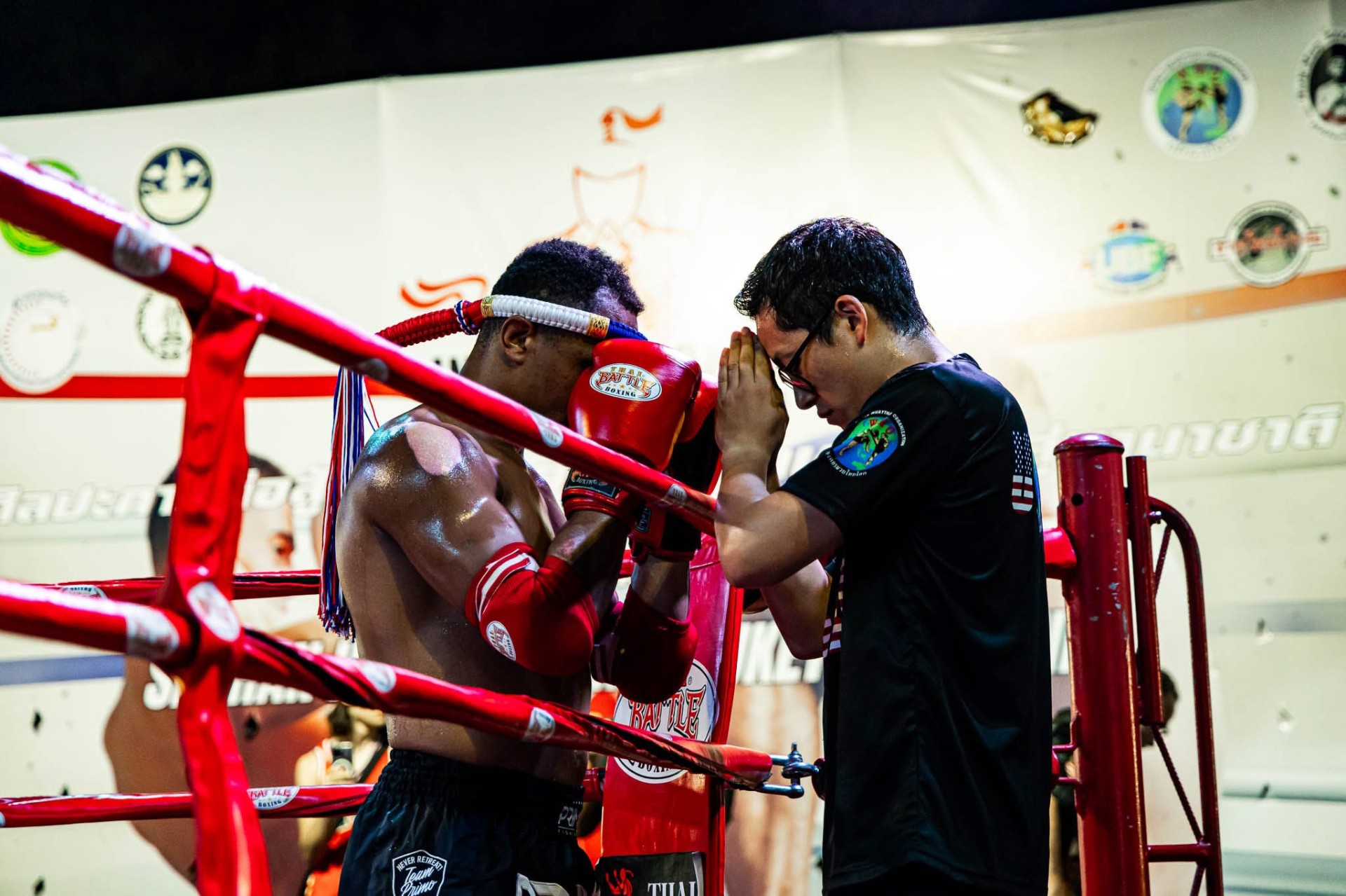 Fighter and coach sharing a moment of prayer ringside