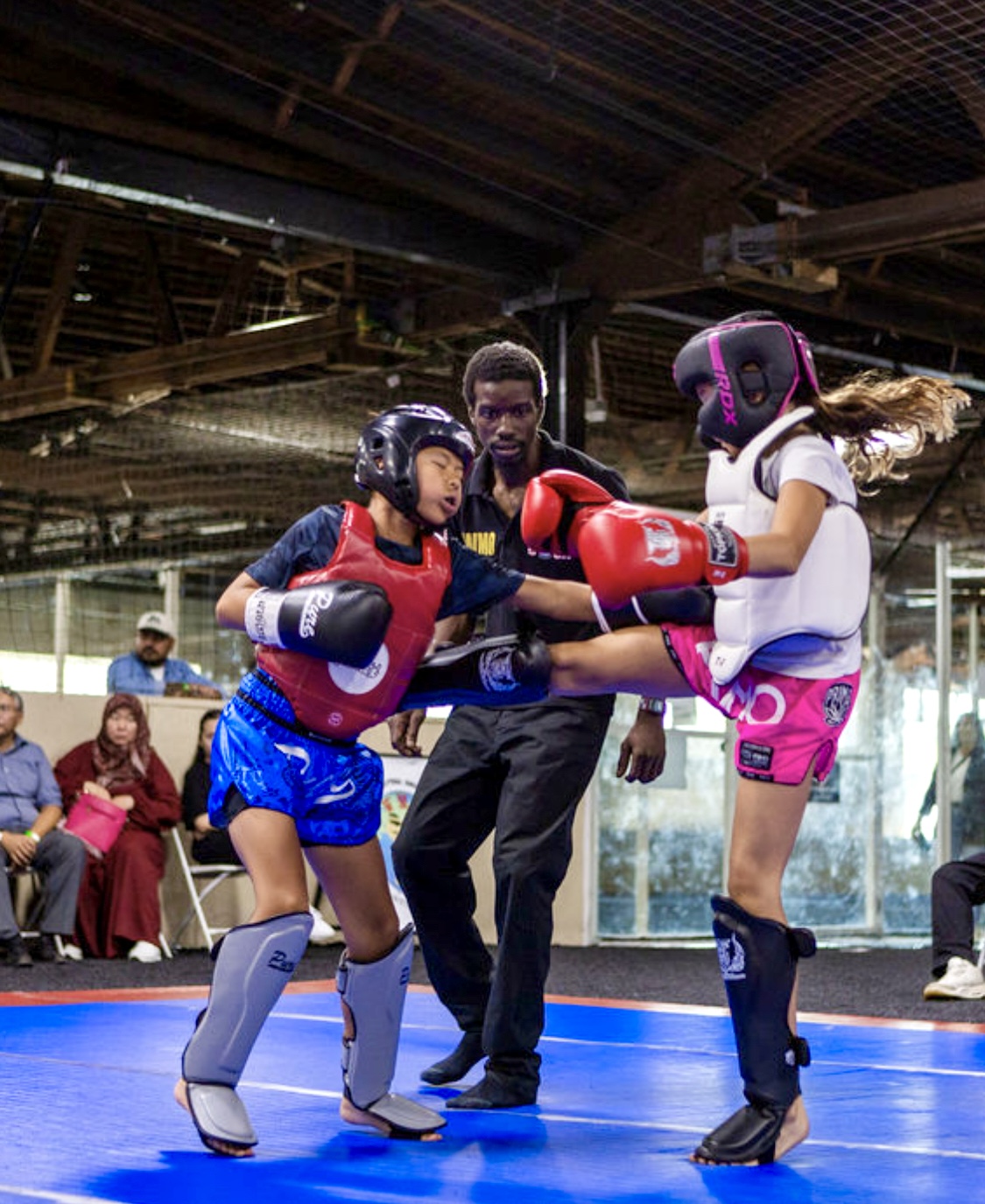 Youth Muaythai athletes sparring under supervision