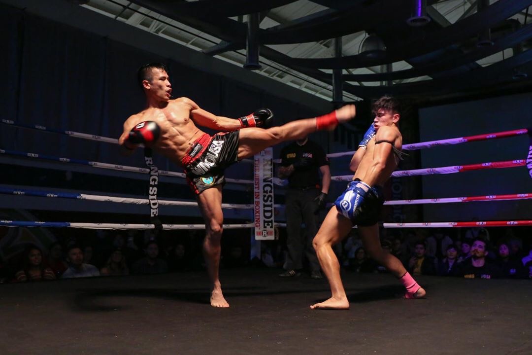 Muaythai athlete landing a head kick during competition