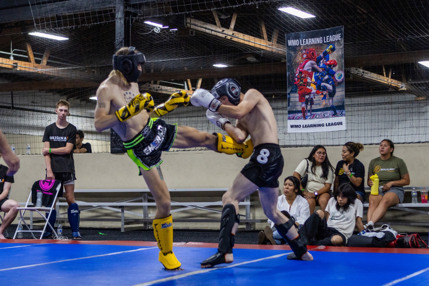 WMO Learning League fighter landing a high kick under the official banner