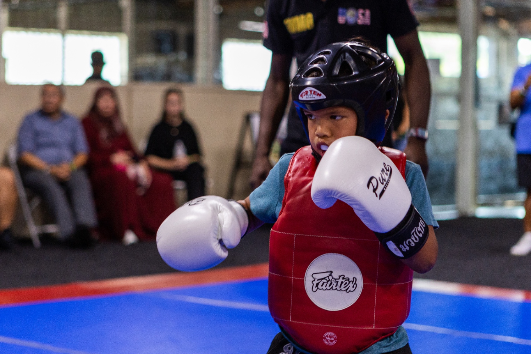 Young Muaythai athlete in guard stance during a Learning League bout
