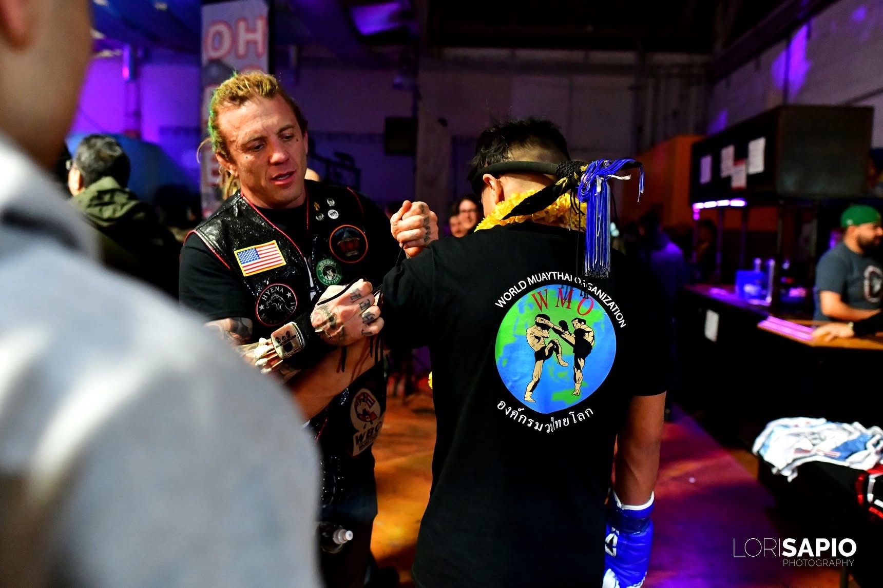 WMO USA cornerman preparing a fighter wearing the World Muaythai Organization shirt before a bout
